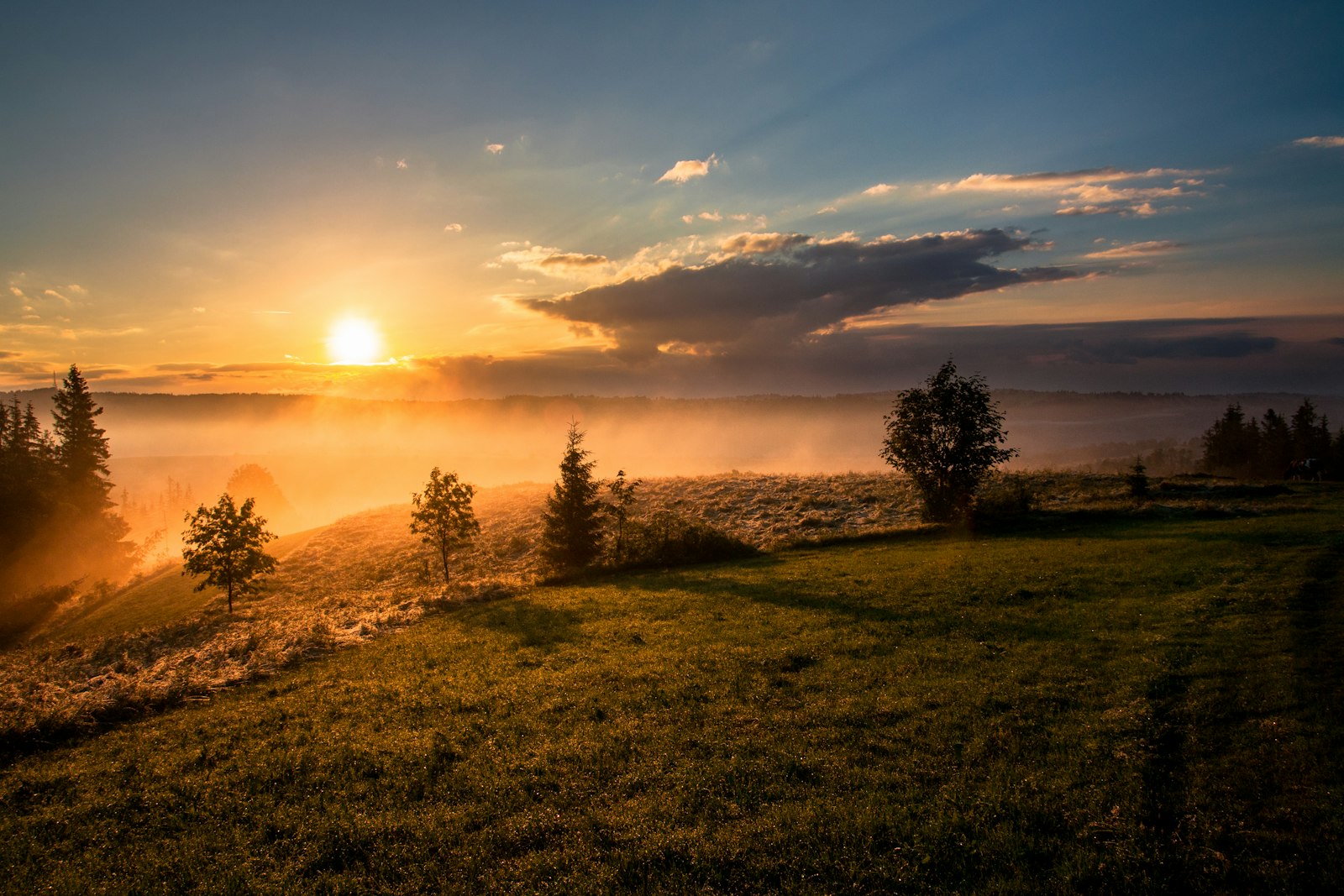 A golden sunset over a misty Montana valley beneath a vast sky